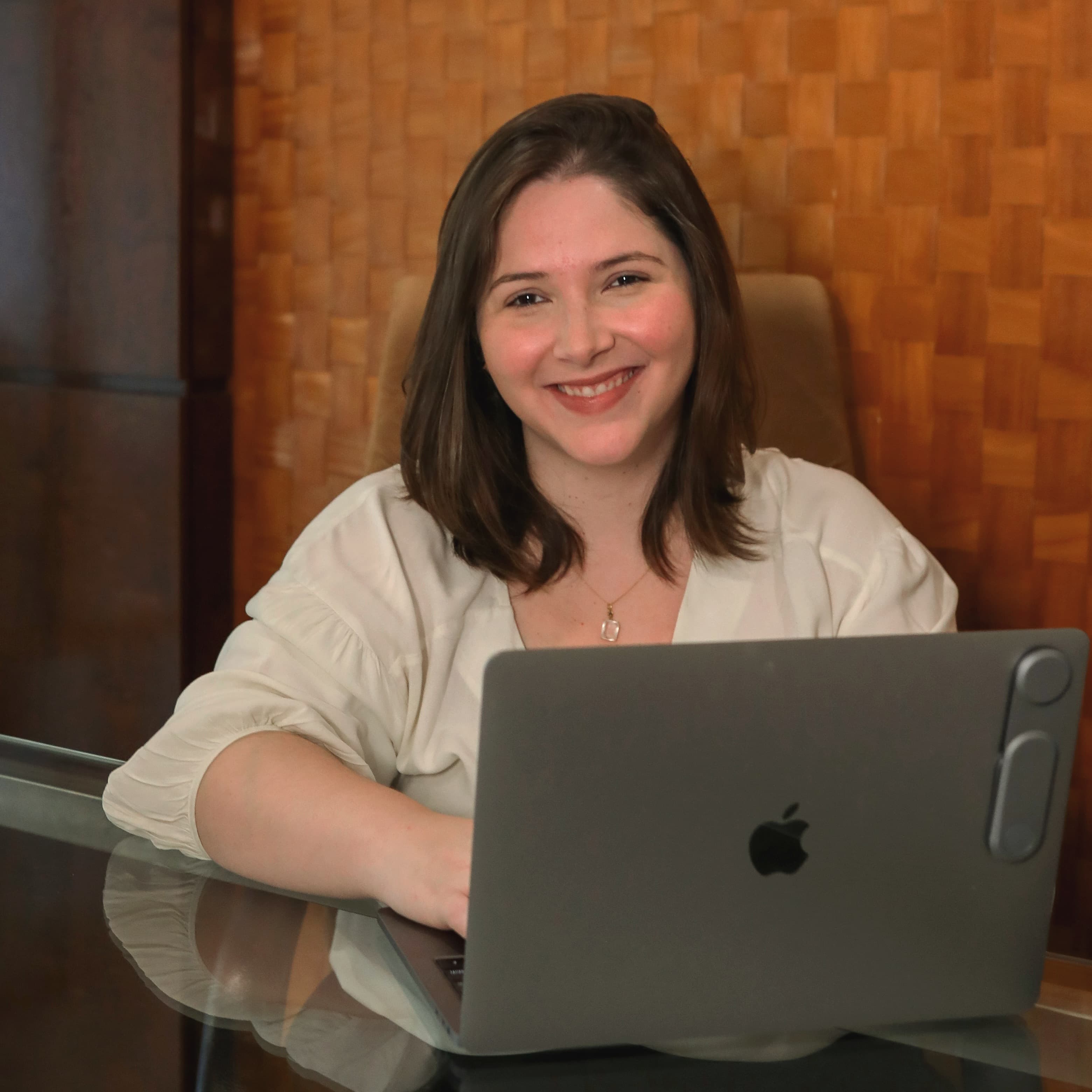 Bárbara Reis sorrindo, sentada com um MacBook