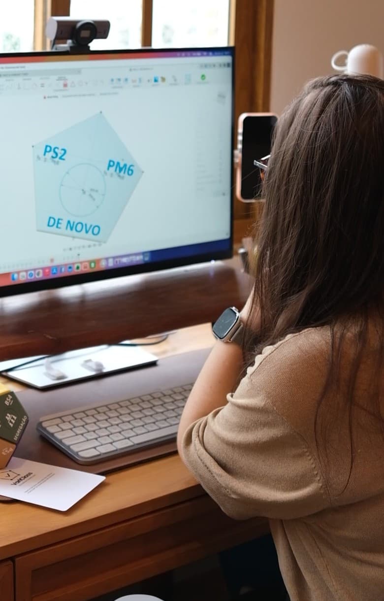 Bárbara Reis de costas, olhando a tela com o modelo 3D de uma face do VariClass